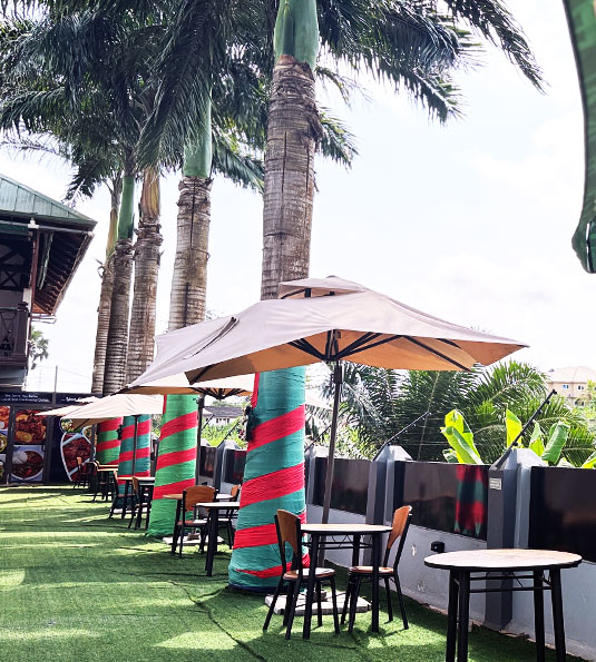 a restaurant outside under coconut trees